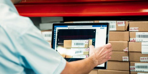 Employee uses a tablet to scan in product barcodes of company stock