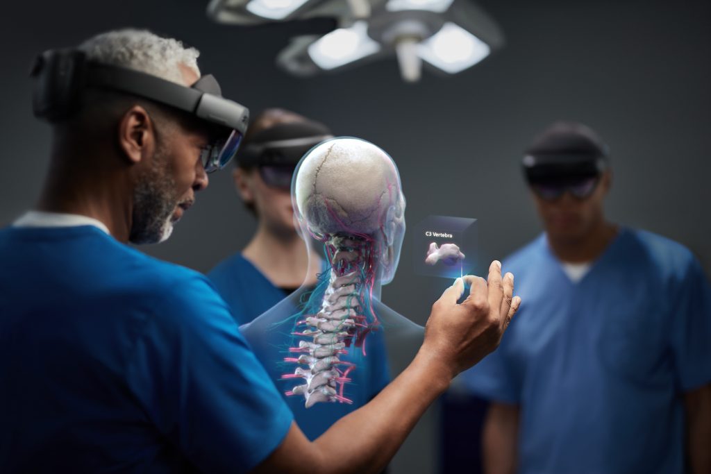 An experienced surgeon makes use of a mixed reality headset to interact with a virtual replica of the spinal column.