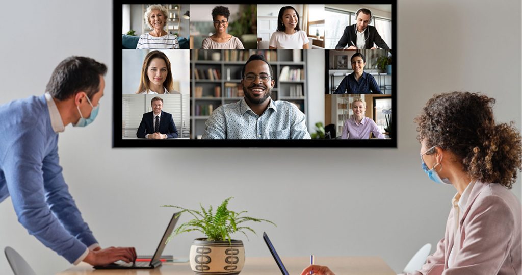 Two office workers in virtual conference with remote workers