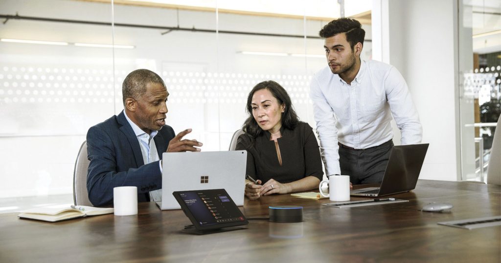 A team of professionals in discussion around the boardroom table