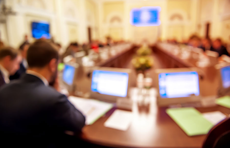 Public sector employees sitting in a meeting room.