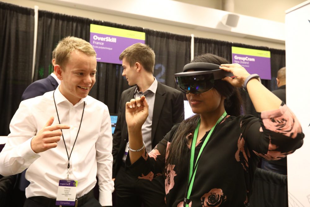 Thomas Galeon stands next to a woman who is wearing virtual reality goggles