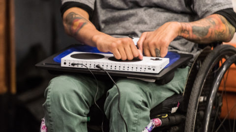 man in a wheelchair uses accessibility gaming device