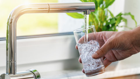 filling glass of water from a tap