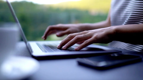Person typing on keyboard.