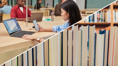 A woman sits in a library with a laptop
