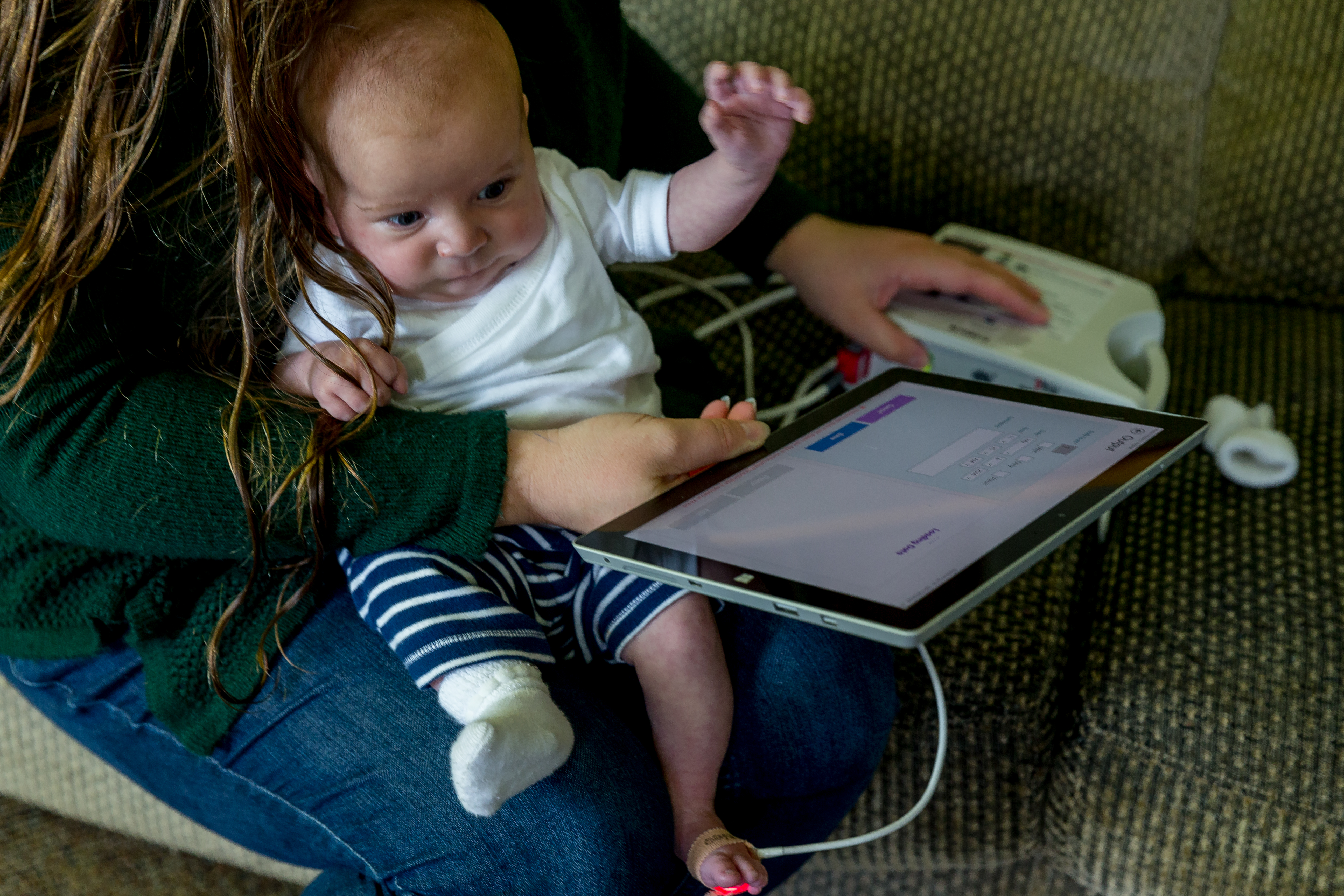 Autumn Parkinson measures Job's heart rate and oxygen saturation, and enters the information using the CHAMP app. (Photography by Scott Eklund/Red Box Pictures)