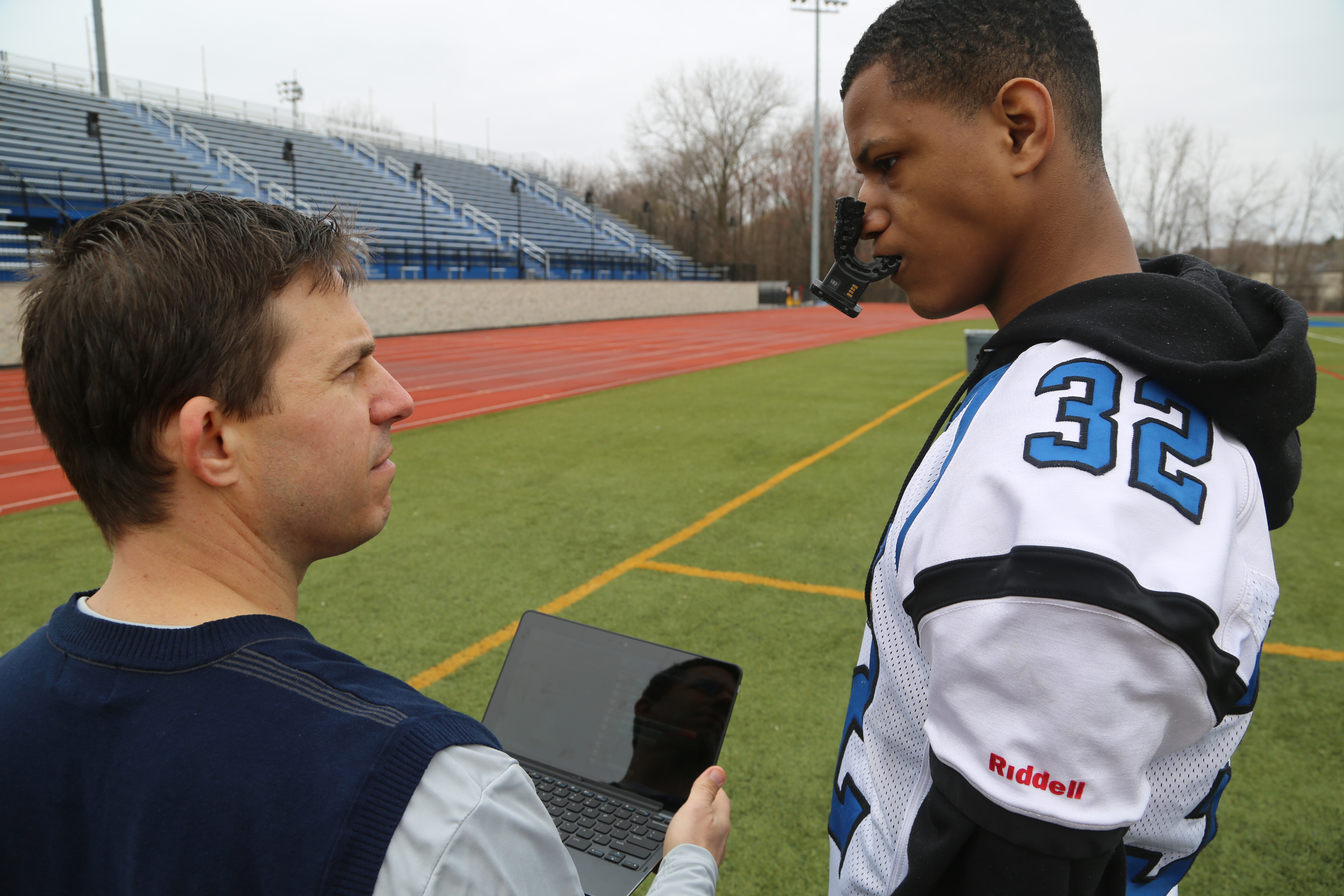 Middletown High School athletic trainer Craig Olejniczak consulting with a player on the team, who is wearing a Vector MouthGuard. (Photo by Kelly Guenther.)