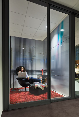 A woman sits with her laptop in a Respite Room.