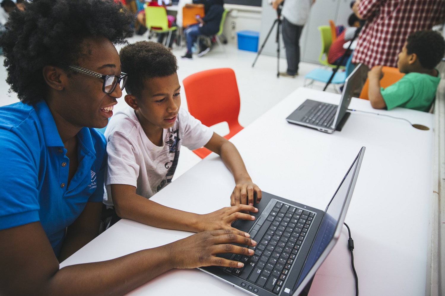 Woman and boy work together on a laptop computer