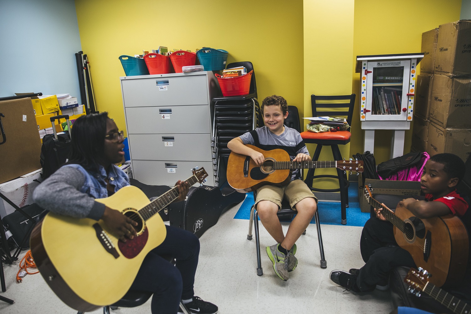 Woman and two boys play guitar