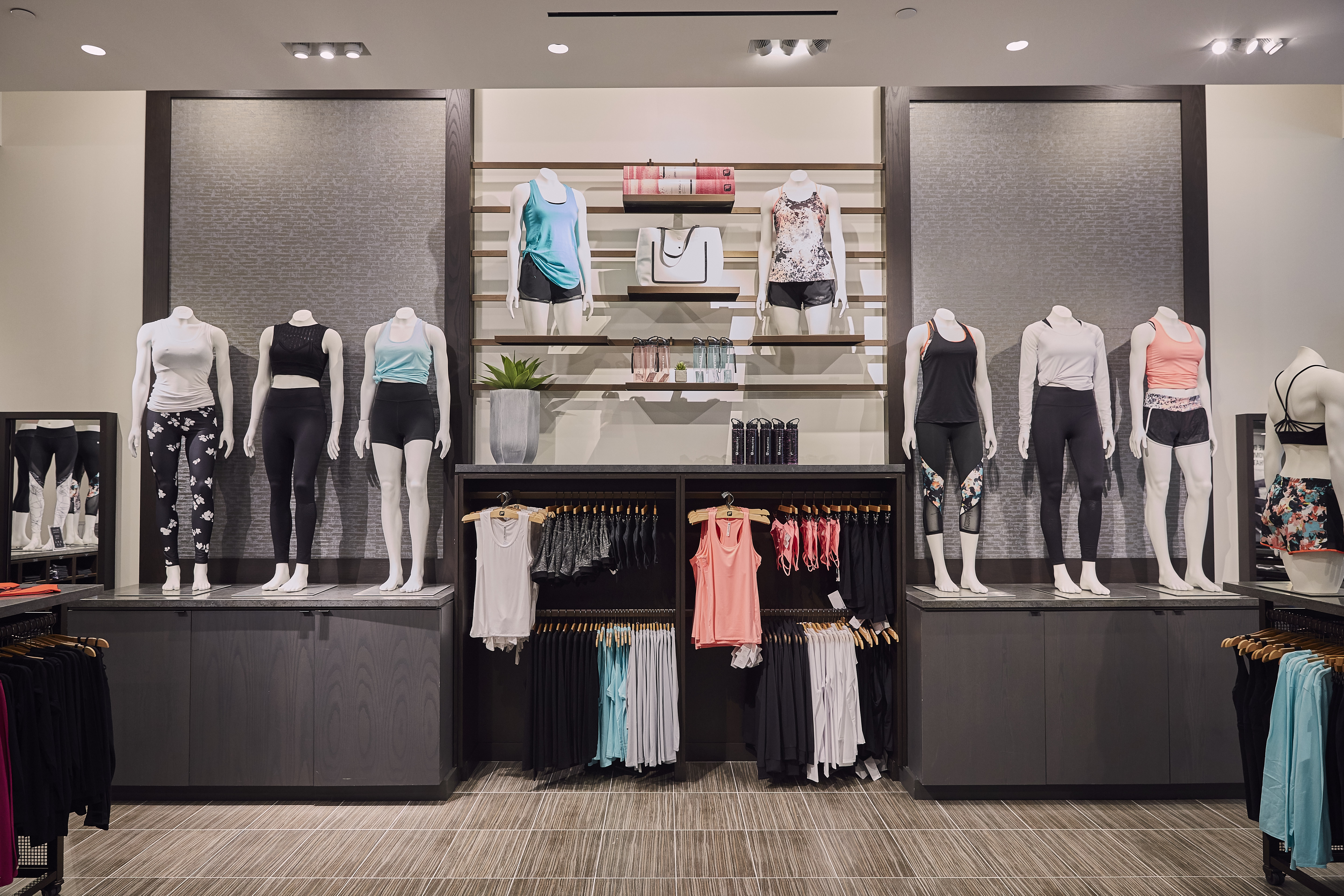Clothing is displayed inside a Fabletics store.