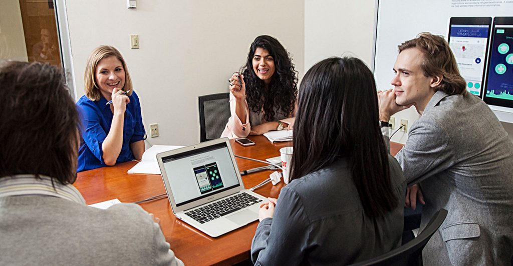 Small group of people talk at a conference table