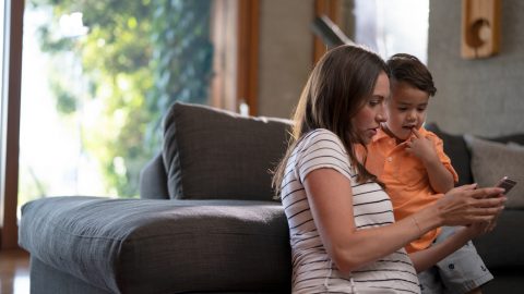 woman and child look at a mobile phone