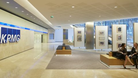 Two people sitting in a KPMG lobby.