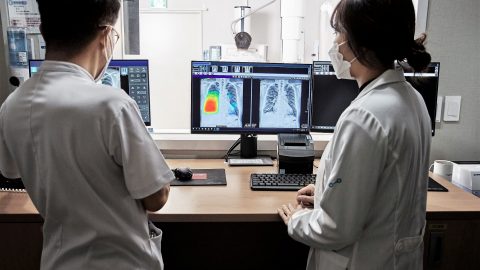 Two health care workers look at scans.