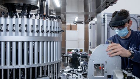 A lab technician uses a mixed reality headset.
