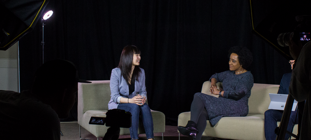 A photo of Amanda Phingbodhipakkiya and Microsoft employee Megan Carpenter talking to each other while sitting in chairs.