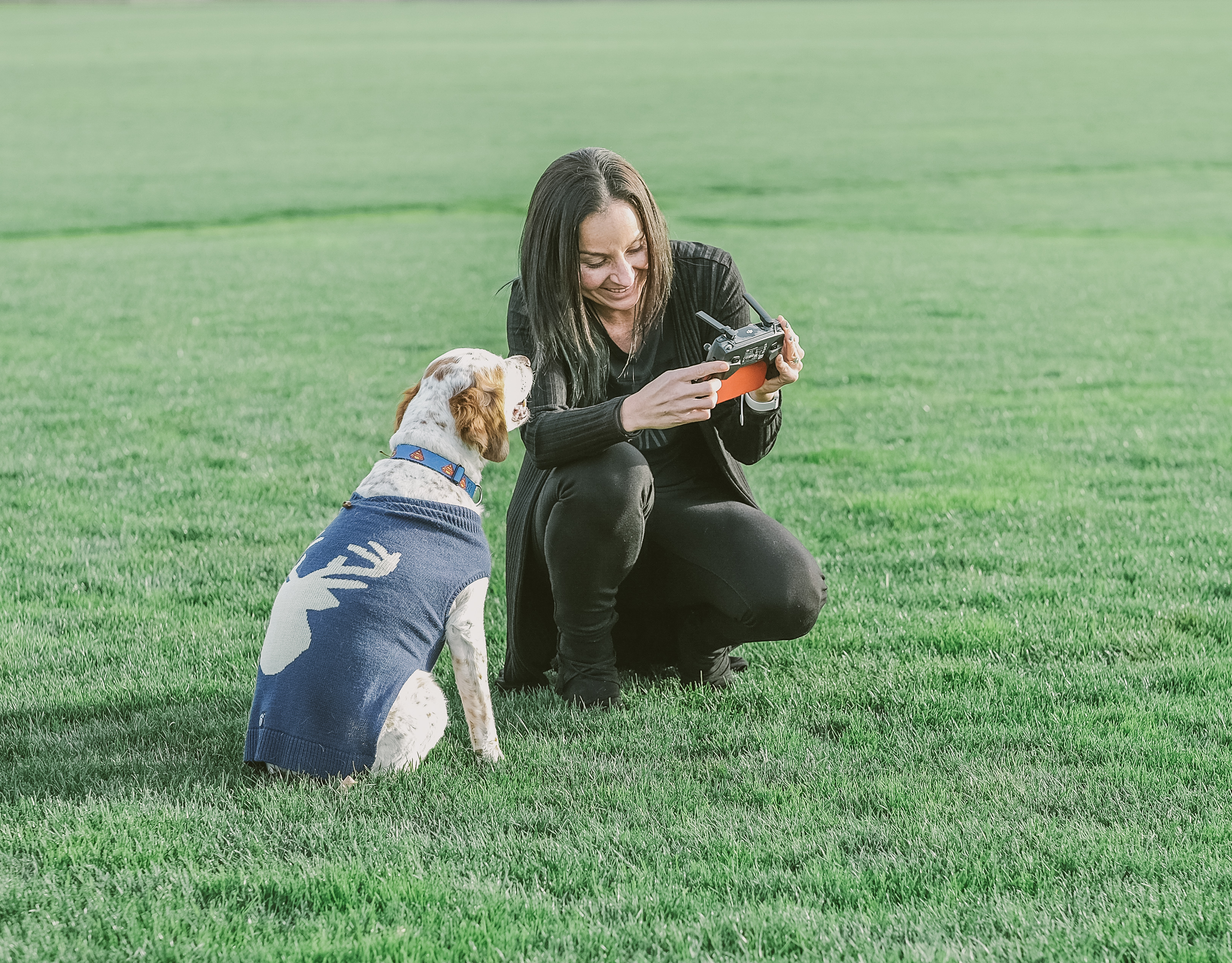 Guada Casuso and her dog, Clark, outside flying a drone