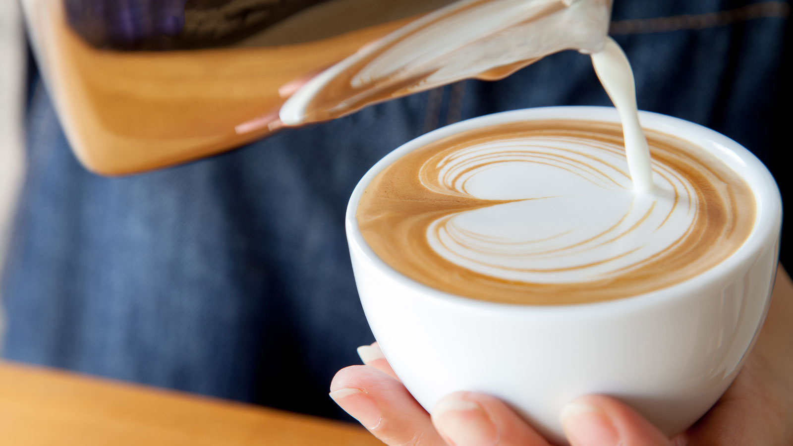 Latte in a coffee mug with a heart design in the milk