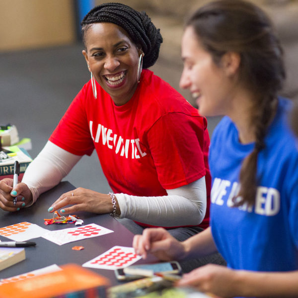 A photo of two women laughing while sitting at a table