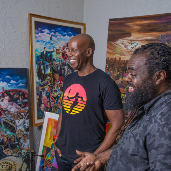 A phooto of Howard Robinson and Richard Thomas laughing and smiling while looking at art pieces in Thomas' New Orleans studio.