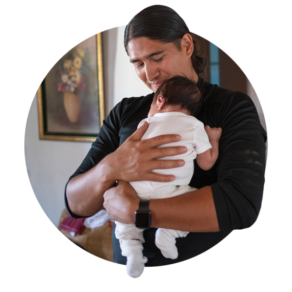 An image of a man holding his newborn son on his chest