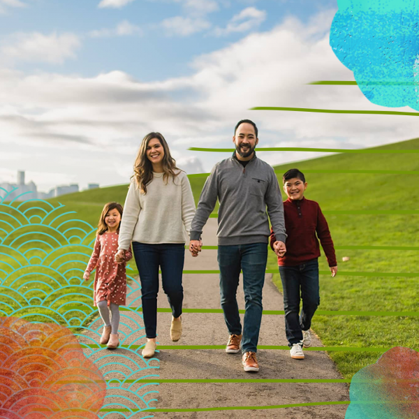 A family - man, woman, and two children - walking in a park