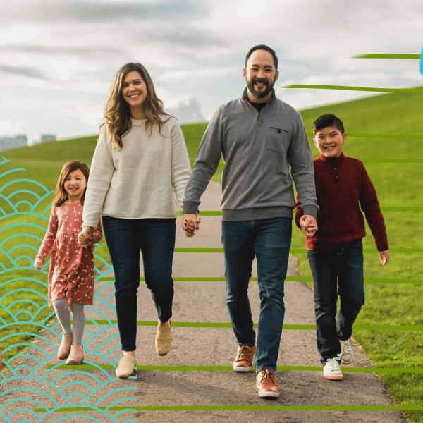 A family - man, woman, and two children - walking in a park