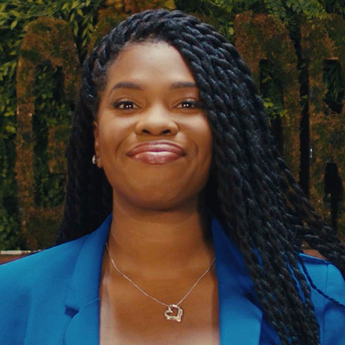 a woman wears a blue jacket and smiles