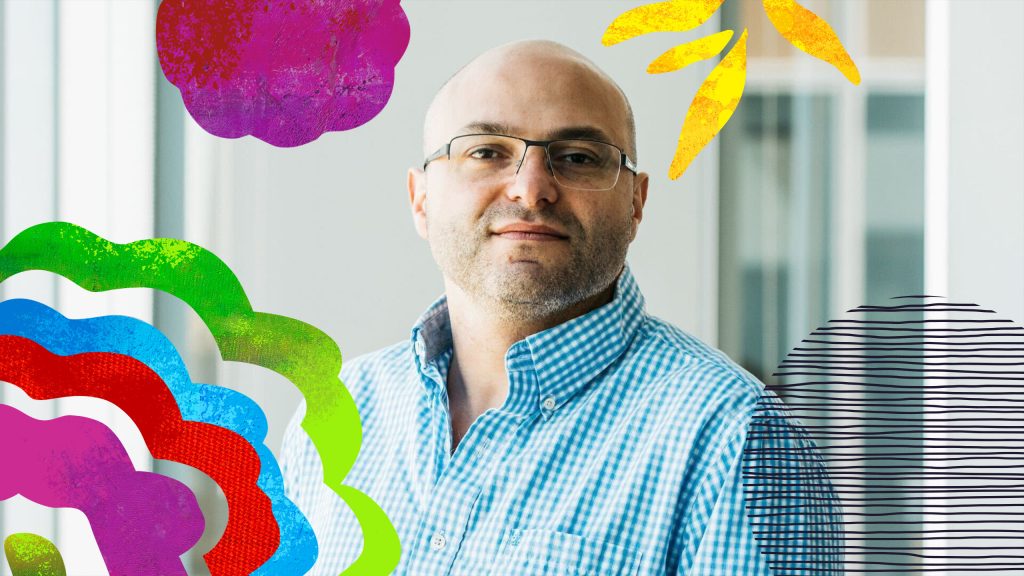 Joseph wearing a blue and white checkered button down with a colorful campaign overlay on top.