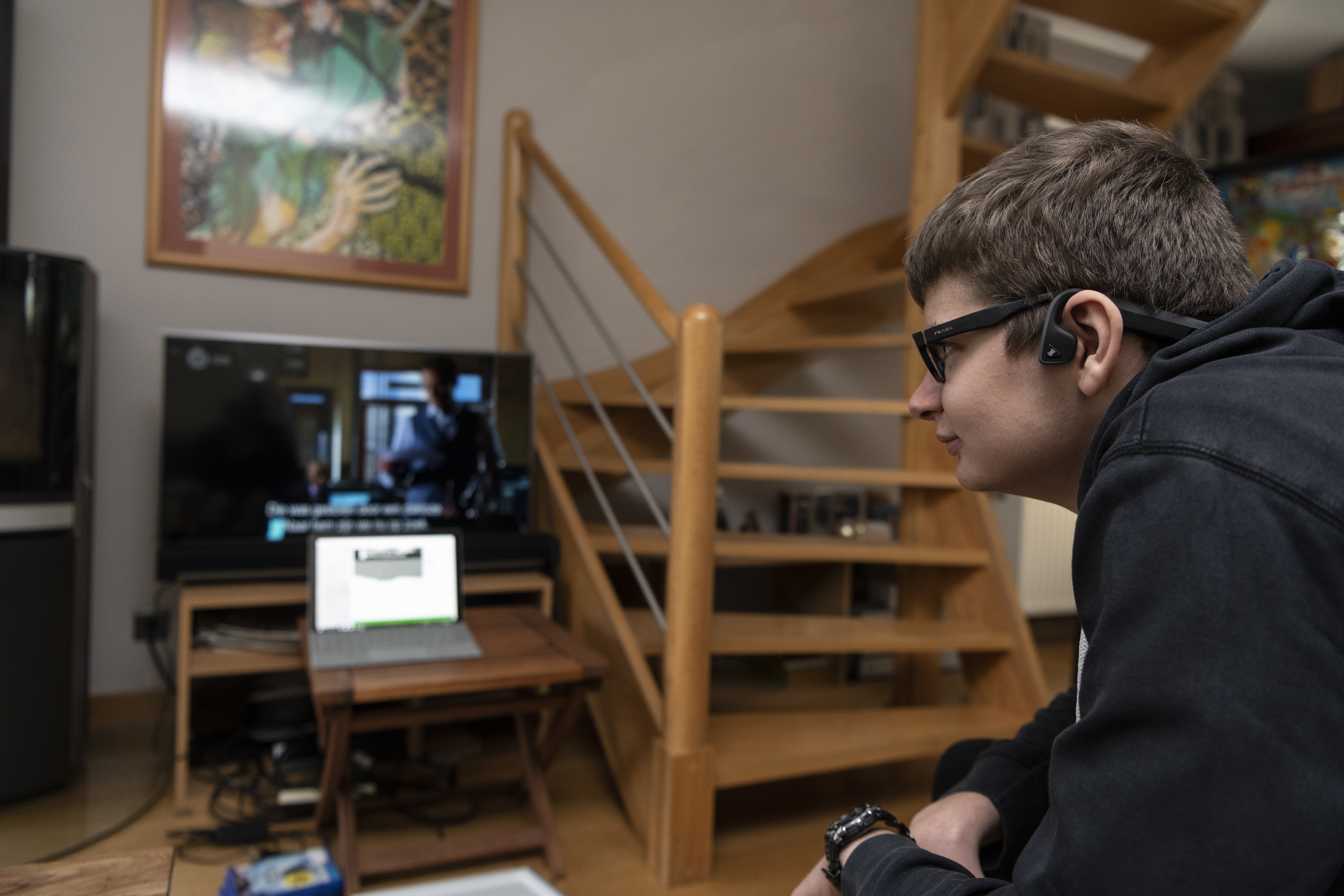 Wouter im Wohnzimmer mit einem Fernseher und Brille