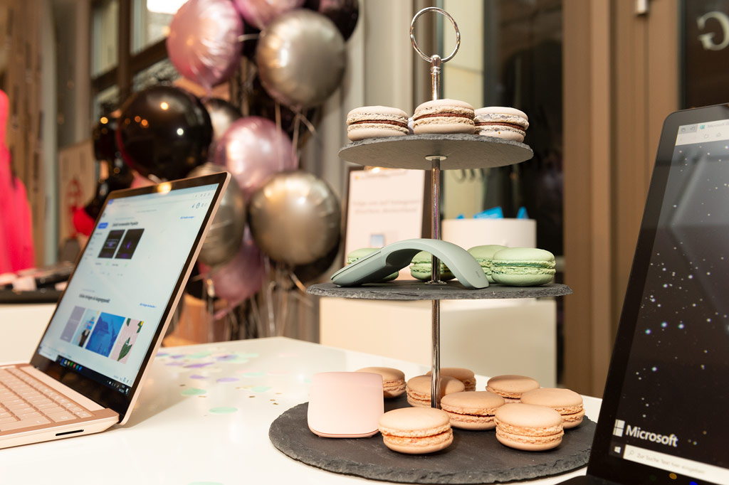 Ein Tisch auf dem Macarons und Laptops stehen