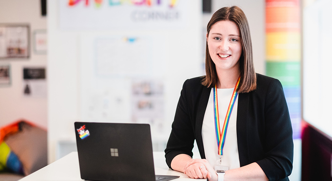 Tiffany Allen neben einem Microsoft Laptop im Office