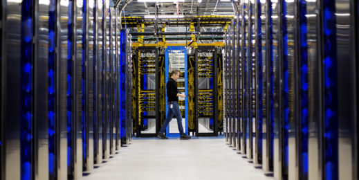 Ein Mann geht durch ein Rechenzentrum.