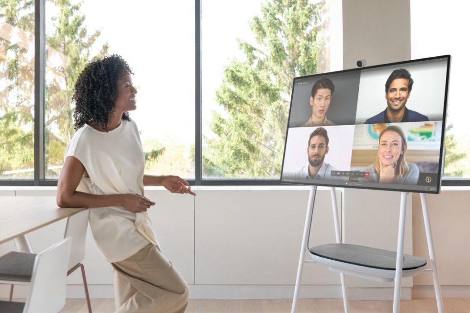Eine Frau steht vor einem Surface Hub 2 und hält ein Meeting ab