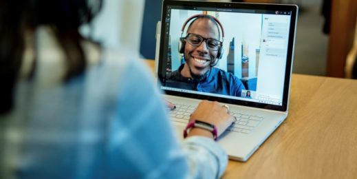 Blick über die Schulter einer Schülerin, die ein Surface Book verwendet um mit ihrem Lehrer via Teams zu videotelefonieren