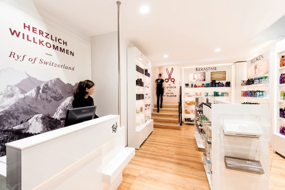 Friseursalon von Ryf Coiffeur. Frau hinter einem Tresen, im Hintergrund der Regale mit Haarpflegeprodukten