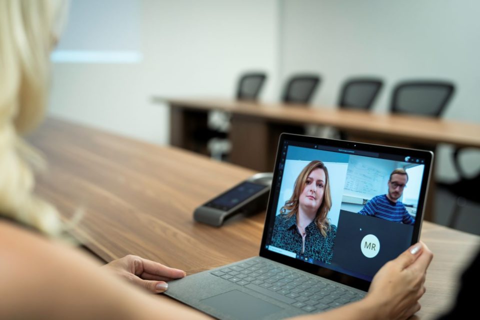 Eine Frau hat einen Video-Call mit drei Arbeitskolleg*innen