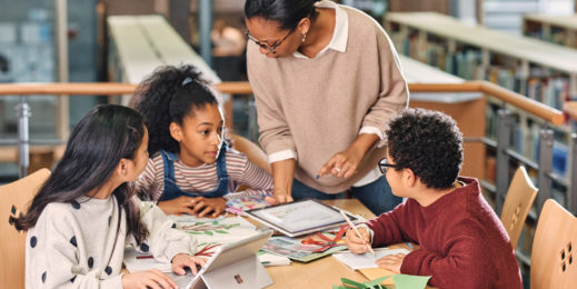 Schüler:innen lernen in Begleitung einer Lehrerin mit Surface Geräten