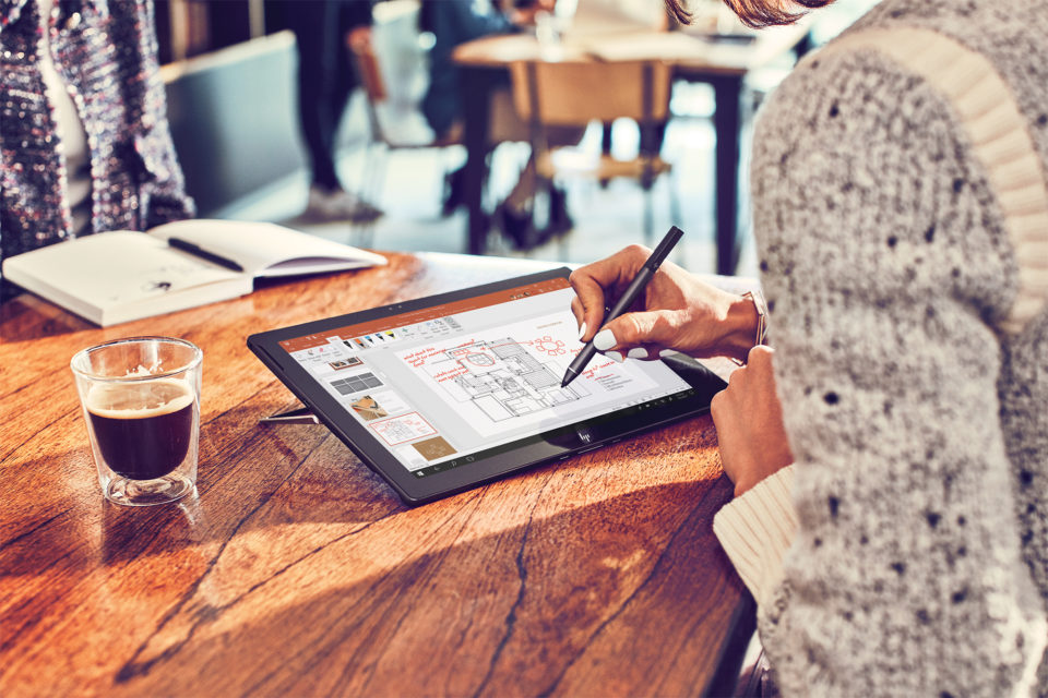 Windows 10 Learning Week: Eine Frau sitzt an einem Windows 10 Gerät und macht Notizen mit