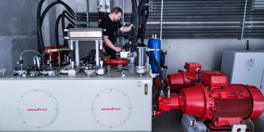 Arbeiter an roter Hydraulikanlage