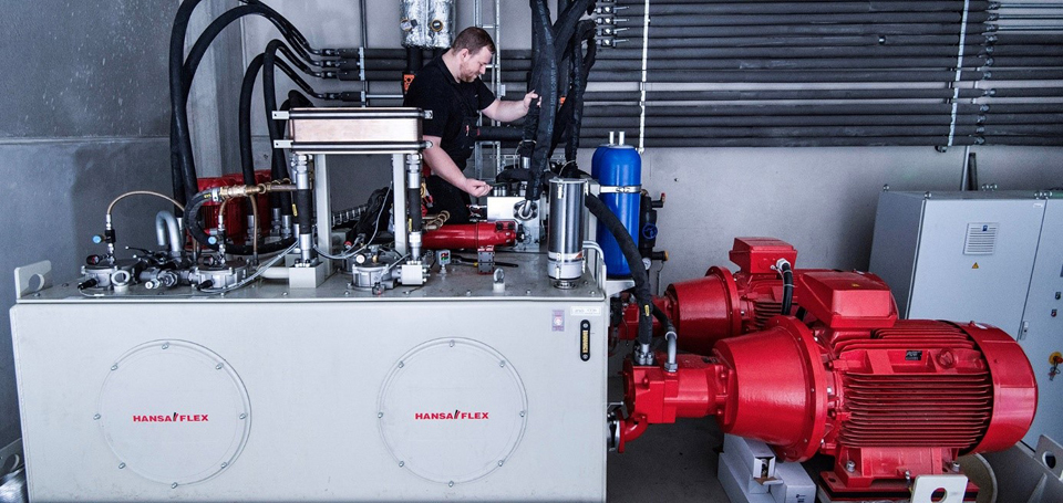 Arbeiter an roter Hydraulikanlage