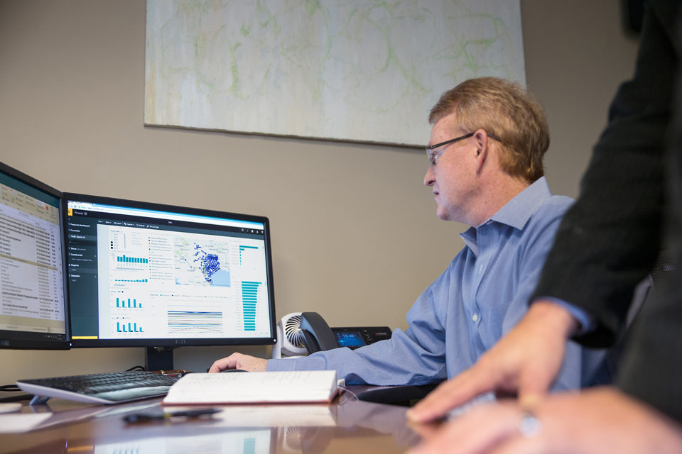 Mann sitzt vor einem großen Bildschirm und wertet Daten aus. Studie zur Cybersicherheit 2020 Wie sich kleine und mittelständische Unternehmen sicher aufstellen