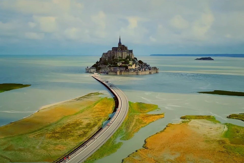 Blick auf die Felsinsel Saint Mont Michel. Eine Straße verläuft direkt drauf zu