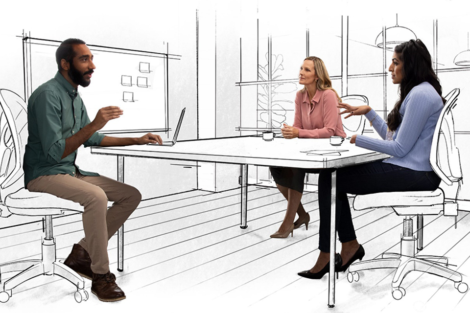 Drei Personen sitzen auf Stühlen an einem Tisch und unterhalten sich.