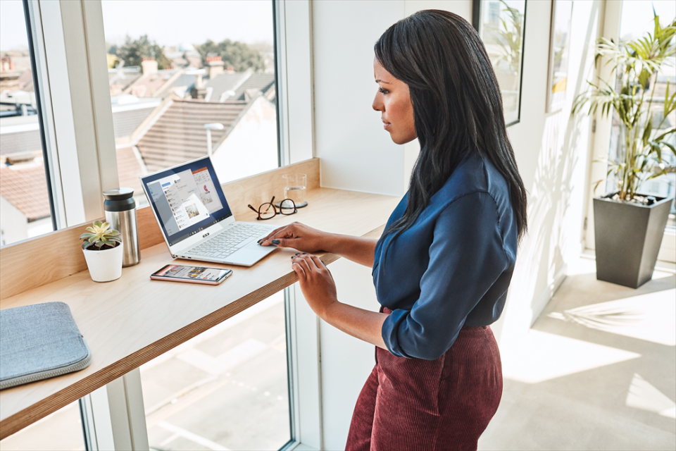 Frau vor Laptop stehend