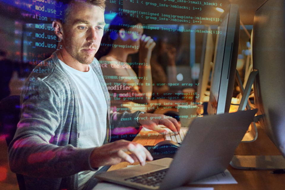 Mann arbeitet an seinem Laptop