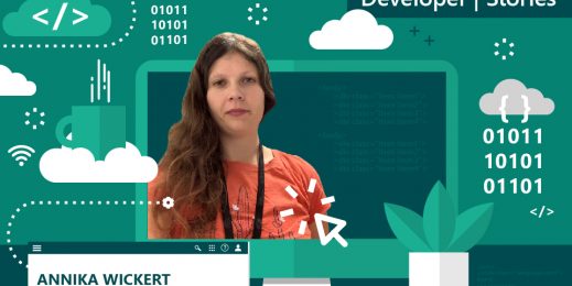 Porträtbild von Annika Wickert. Sie trägt ein orangefarbenes T-Shirt, ein Lanyard und offene lockige Haare.