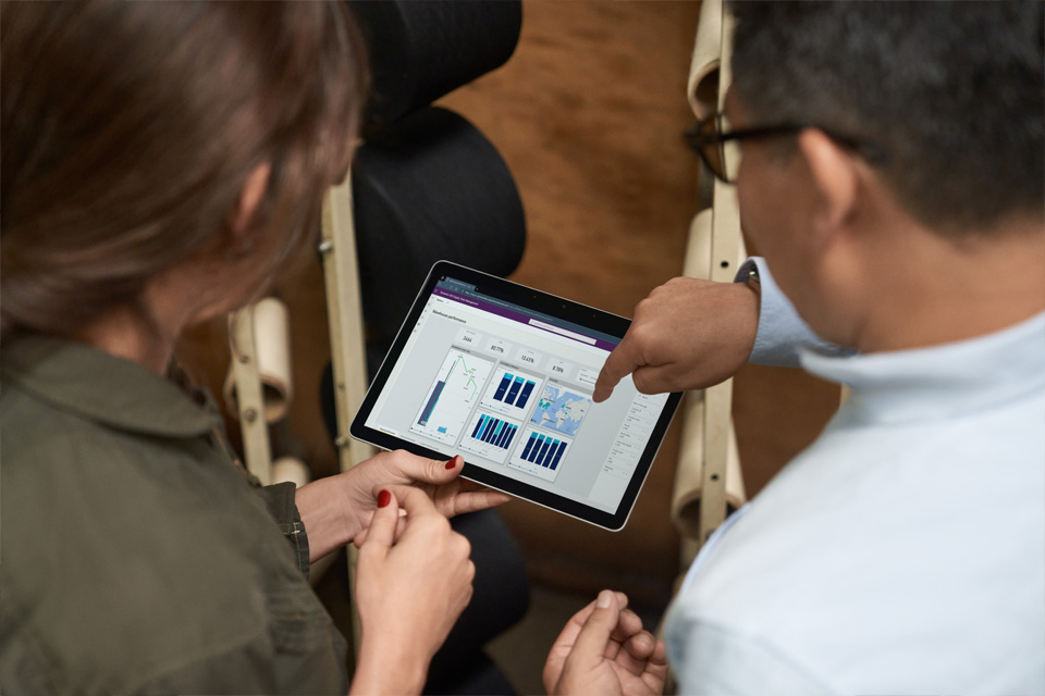 Frau und Mann schauen gemeinsam auf ein Tablet mit einer Grafik